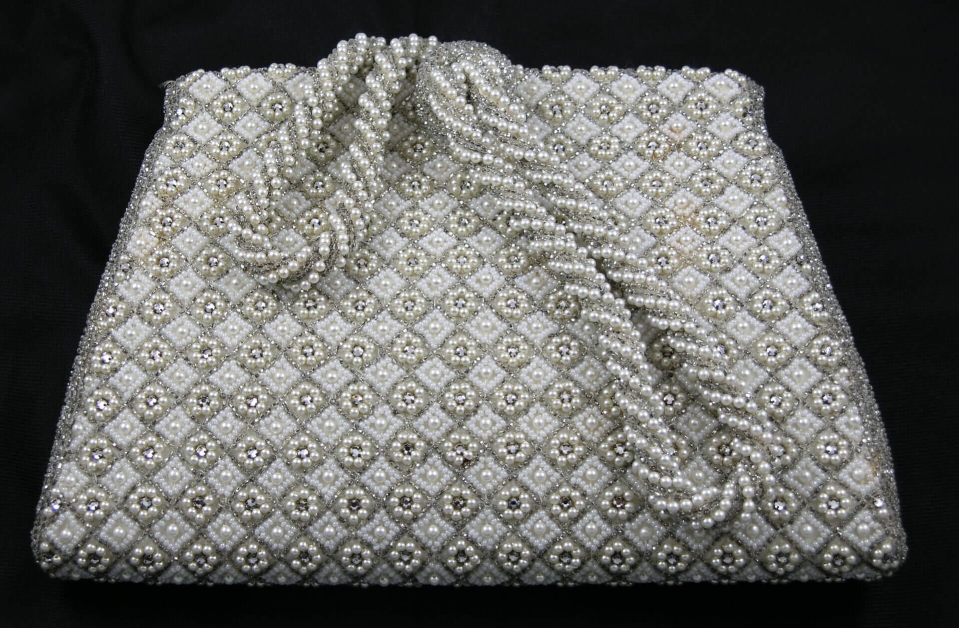 Beaded clutch with pearl and rhinestone design.