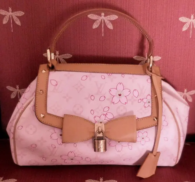 Pink and tan Louis Vuitton handbag with cherry blossoms.