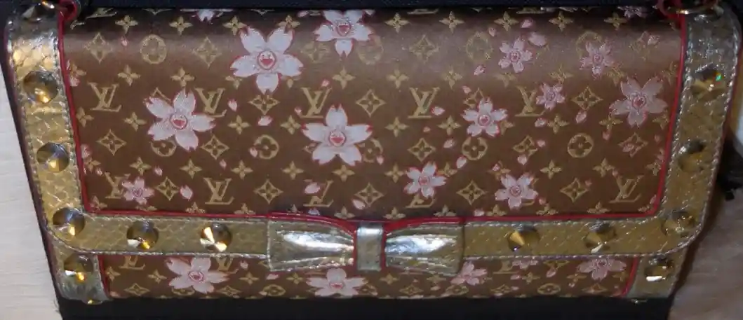 Brown floral Louis Vuitton handbag with gold accents.