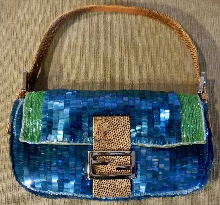 Blue sequined handbag with leather strap.