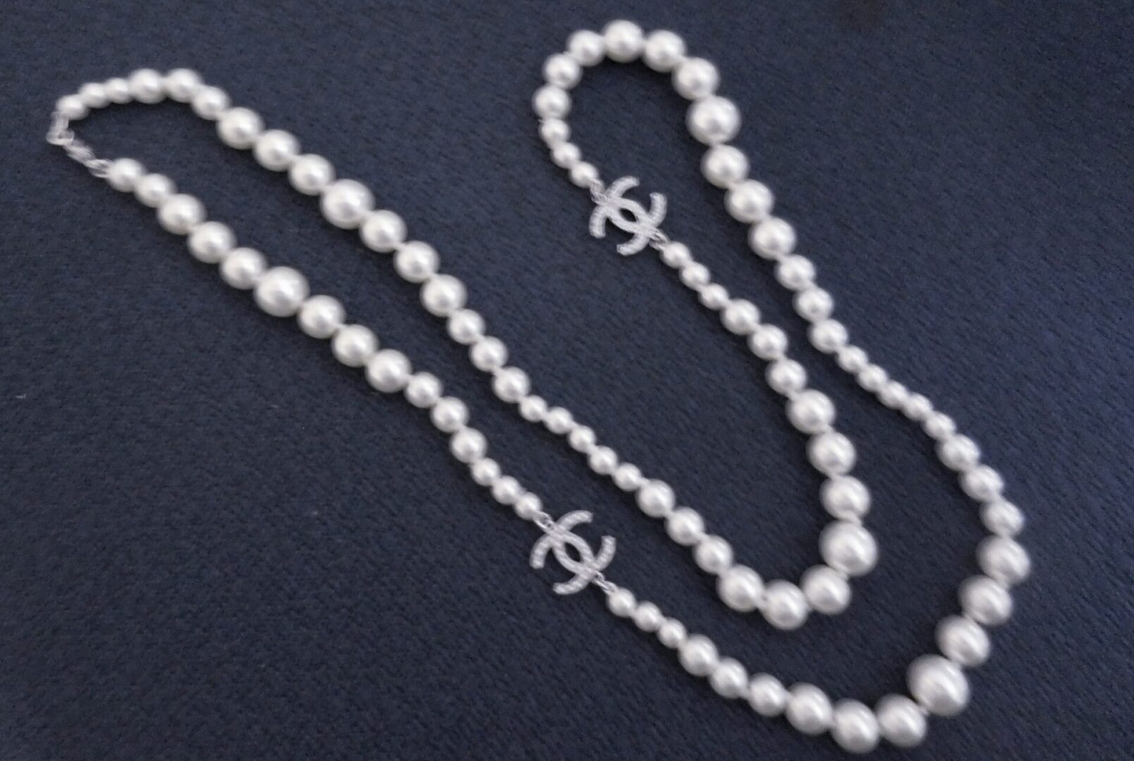 Pearl necklace with Chanel charms.