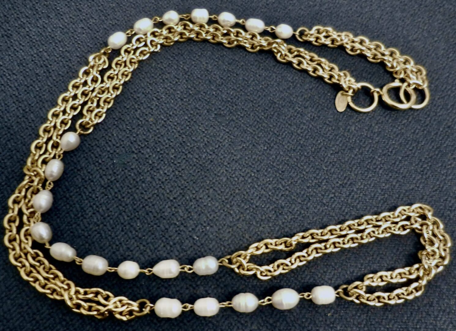 Gold chain necklace with white pearls.