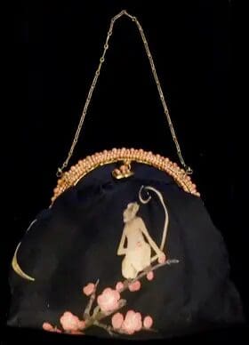 Black clutch with monkey and blossoms.